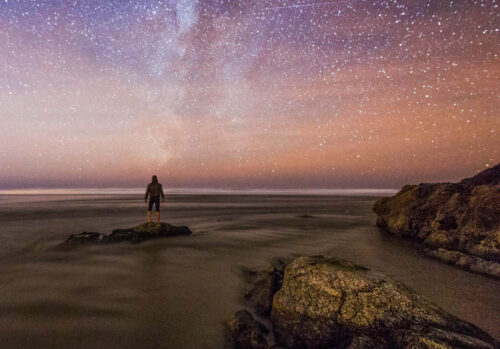 evening stars beach rocks person