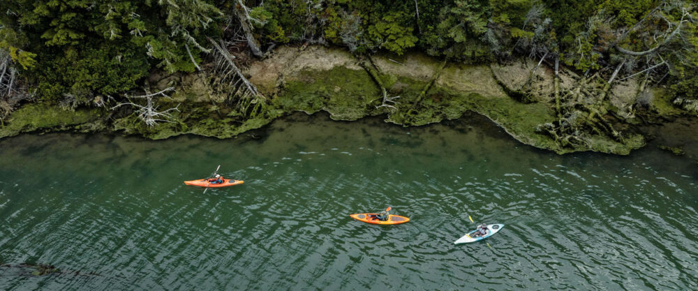 Aerial view of kayaks next to cliffs.