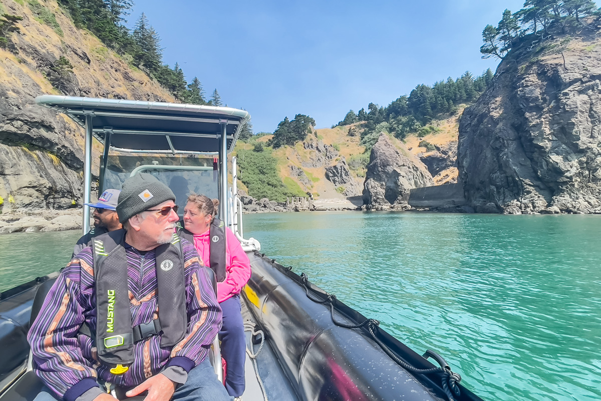 People in a boat next to steep cliffs